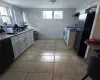 Kitchen with black appliances, white cabinetry,  tile and wood floors