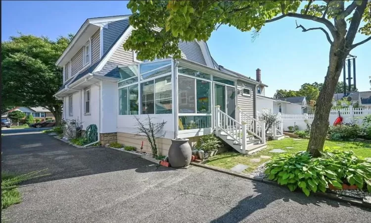 View of side of home featuring a sunroom