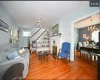 Living room with ceiling fan with notable chandelier and light hardwood / wood-style floors