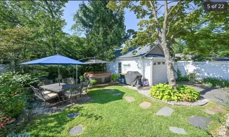 View of yard with an outdoor structure, a hot tub, and a garage