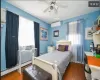 Bedroom featuring an AC wall unit, ceiling fan, a baseboard radiator, and dark hardwood / wood-style floors