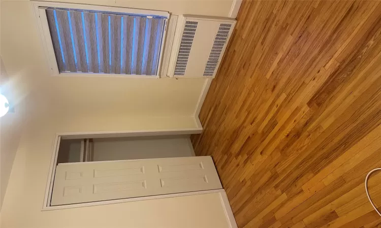 Unfurnished bedroom featuring light hardwood / wood-style floors, radiator, and a closet