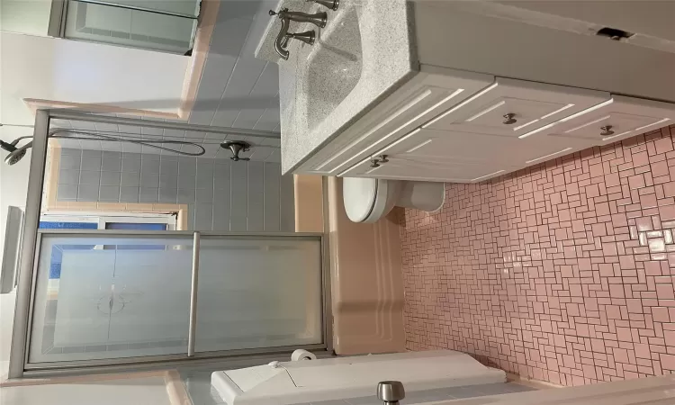 Full bathroom featuring vanity, toilet, and enclosed tub / shower combo