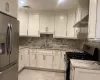 Kitchen with sink, light stone countertops, stainless steel appliances, and tasteful backsplash