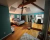 Bedroom featuring lofted ceiling with beams, light hardwood / wood-style floors, and ceiling fan