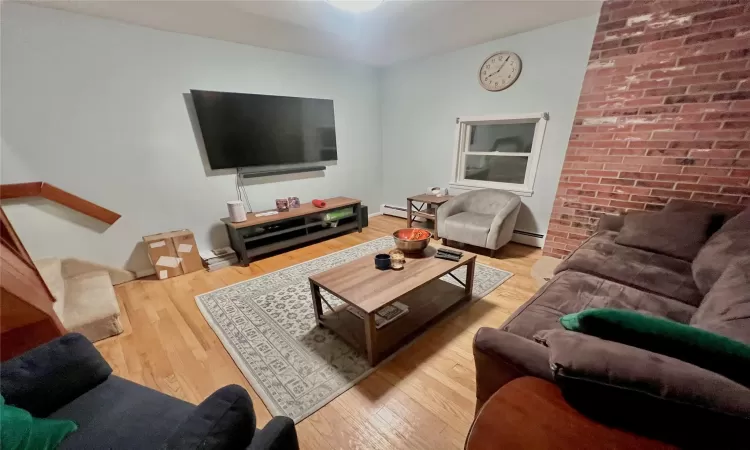 Living room featuring light hardwood / wood-style floors and a baseboard heating unit