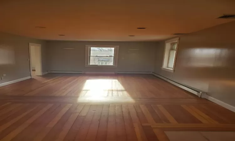 Spare room with hardwood / wood-style floors and a baseboard radiator