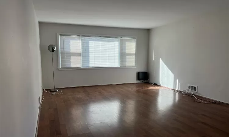 Unfurnished room with dark wood-type flooring