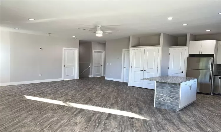 Kitchen featuring a center island, ceiling fan, stainless steel fridge, dark hardwood / wood-style flooring, and white cabinetry