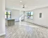 Unfurnished living room featuring electric panel, light hardwood / wood-style floors, plenty of natural light, and ceiling fan