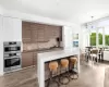 Kitchen with decorative backsplash, appliances with stainless steel finishes, sink, white cabinetry, and hanging light fixtures