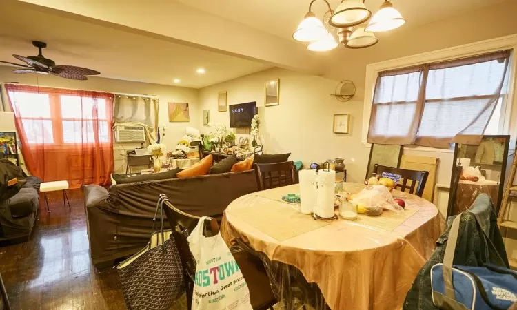 Dining room with plenty of natural light, dark hardwood / wood-style flooring, and ceiling fan with notable chandelier