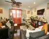 Living room with dark hardwood / wood-style floors, ceiling fan, electric panel, and cooling unit