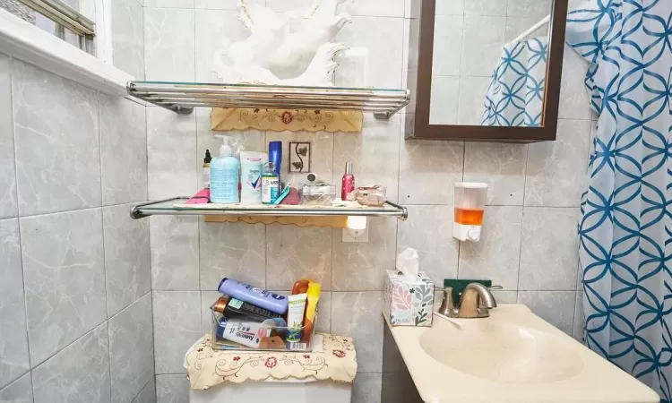 Bathroom featuring sink and tile walls