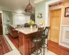 Kitchen featuring crown molding, ceiling fan, hanging light fixtures, and light wood-type flooring