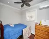 Bedroom with ceiling fan, dark wood-type flooring, crown molding, a baseboard radiator, and an AC wall unit