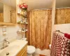 Bathroom featuring backsplash, vanity, tile walls, and toilet