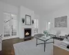 Living room featuring dark wood-type flooring, an inviting chandelier, french doors, ornamental molding, and a fireplace