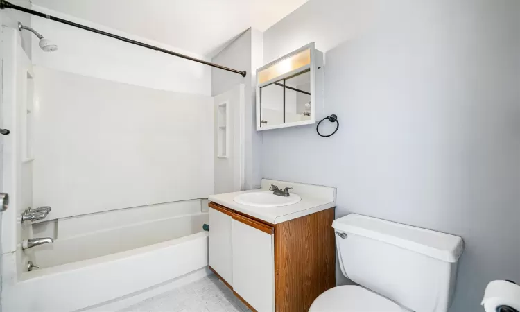 Full bathroom featuring vanity, shower / bath combination, and toilet