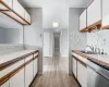 Kitchen with dishwasher, white cabinetry, and sink