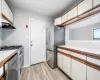 Kitchen with white cabinets, light wood-type flooring, and stainless steel appliances