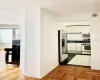 Kitchen with stainless steel refrigerator with ice dispenser, stove, dark parquet floors, and white cabinetry