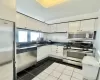 Kitchen featuring white cabinetry, sink, dark tile patterned floors, and appliances with stainless steel finishes