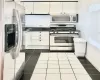 Kitchen with white cabinets, appliances with stainless steel finishes, and dark tile patterned floors