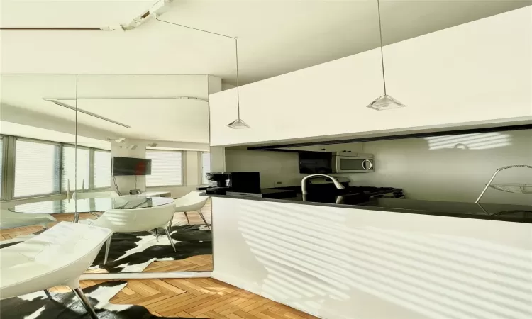 Kitchen featuring parquet floors, hanging light fixtures, and range