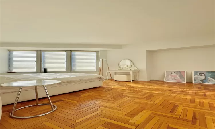 Bedroom with light parquet flooring