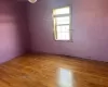 Unfurnished room with a wealth of natural light, brick wall, and hardwood / wood-style flooring