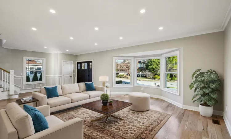 Virtually StagedLiving room with light wood-type flooring and crown molding