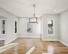 Unfurnished dining area with light wood-type flooring and an inviting chandelier