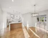 Kitchen featuring appliances with stainless steel finishes, backsplash, white cabinets, a kitchen island, and hanging light fixtures