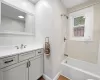 Bathroom featuring hardwood / wood-style flooring, shower / bath combination with curtain, and vanity