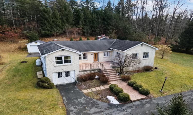 View of front of property featuring a front yard, an outbuilding, and a garage