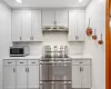 Kitchen with decorative backsplash, light stone counters, and appliances with stainless steel finishes