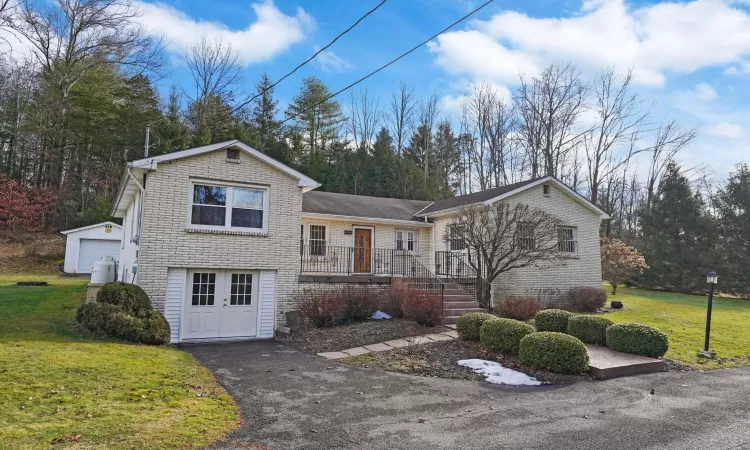 Home with an outbuilding, a front yard, and a garage