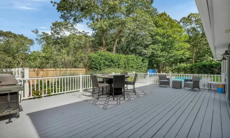 Wooden deck featuring outdoor lounge area and a grill