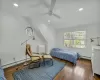 Bedroom with dark wood-type flooring, vaulted ceiling, ceiling fan, and a baseboard heating unit