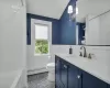 Bathroom featuring vanity, a baseboard heating unit, tile patterned floors, toilet, and tile walls