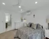 Bedroom featuring ensuite bathroom, an AC wall unit, ceiling fan, and ornamental molding