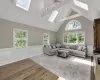 Living room with baseboard heating, a skylight, ceiling fan, and hardwood / wood-style flooring