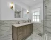 Bathroom with a tile shower, vanity, and tile walls