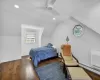 Bedroom with ceiling fan, dark hardwood / wood-style flooring, a baseboard heating unit, an AC wall unit, and vaulted ceiling