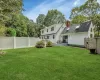 Rear view of property featuring a yard and a wooden deck