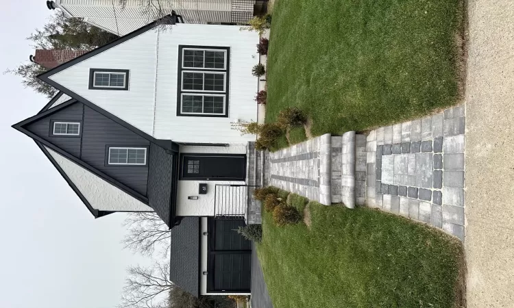 View of front of house featuring a garage, a front yard, driveway, and a chimney