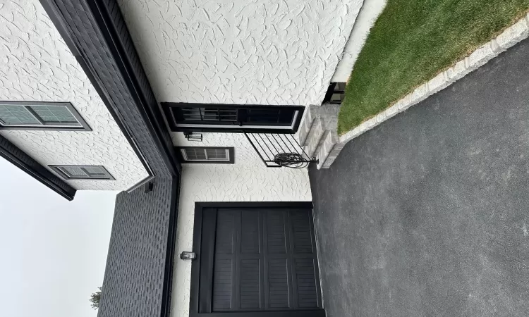 View of front of home with driveway, an attached garage, and a front lawn