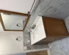 Bathroom with vanity, an enclosed shower, tile walls, and toilet