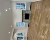 Kitchen featuring stove, dishwashing machine, ventilation hood, sink, and light hardwood / wood-style flooring